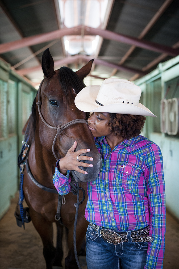 Barrel racing African American cowgirl and her horse